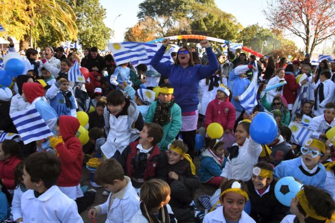 Desde Uruguay, en la localidad de San Javier, departamento de Río Negro, un grupo de niños y adultos celebra el gol de Suárez.