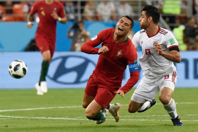 El defensa iraní Morteza Pouraliganji (derecha) va en busca del balón con el delantero portugués Cristiano Ronaldo en el último partido del Grupo B.