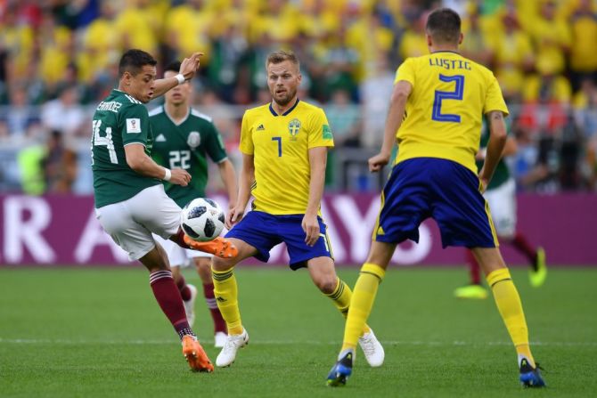 El delantero de México Javier Hernandez y el mediocampista sueco Sebastian Larsson disputan un balón.