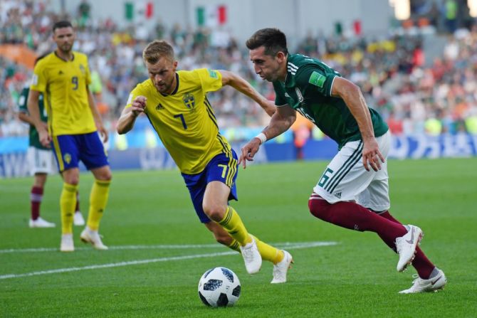 Sebastian Larsson de Suecia y Héctor Herrera de México disputan un balón. El partido México - Suecia terminó 0 - 0 en la primera parte.