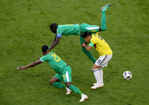 Radamel Falcao de Colombia es atacado por Cheikhou Kouyate and Keita Balde de Senegal.