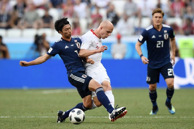 Rafal Kurzawa de Polonia ataca a Gaku Shibasaki de Japón en el último juego del Grupo H.