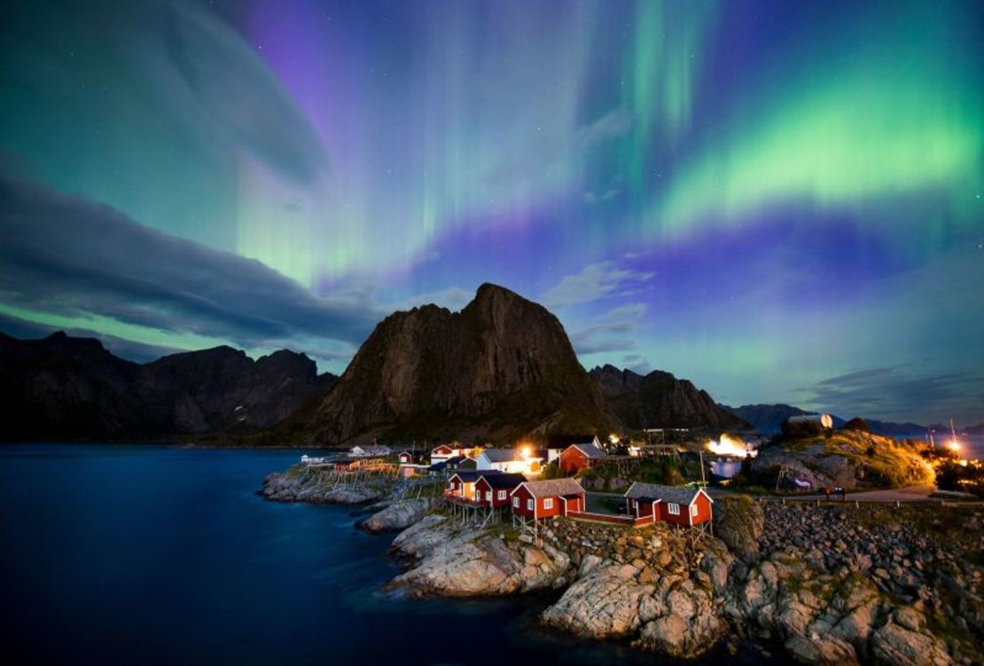 La aurora boreal ilumina el cielo sobre Reinefjorden en Reine, en las islas Lofoten, Noruega.