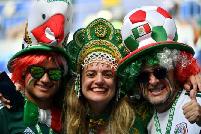 Hinchas de México posan con una hincha de Brasil antes del partido entre las selecciones en el estadio de Samara en Rusia.