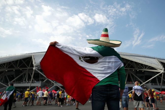 Hinchas de México posan con una hincha de Brasil antes del partido entre las selecciones en el estadio de Samara en Rusia.