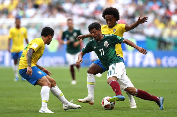 Carlos Vela de México lucha un balón con Willian y Fagner de Brazil en la primera parte del partido entre sus selecciones en los octavos de final de Rusia 2018.