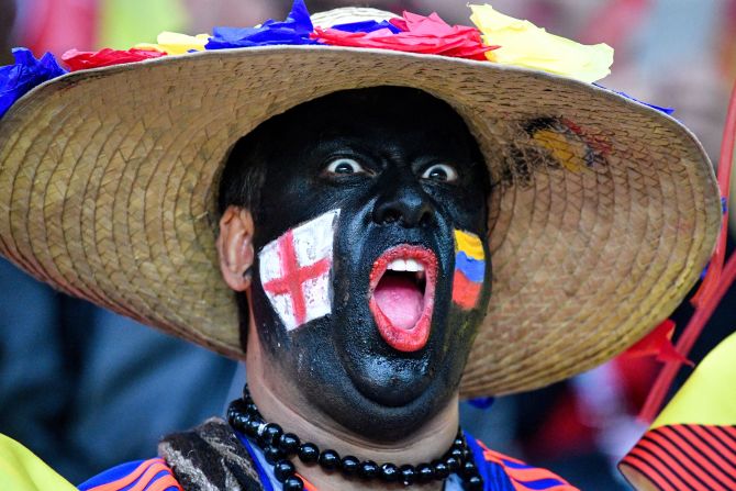 Un hombre con las banderas de Inglaterra y Colombia antes del partido que enfrentará a ambas selecciones.