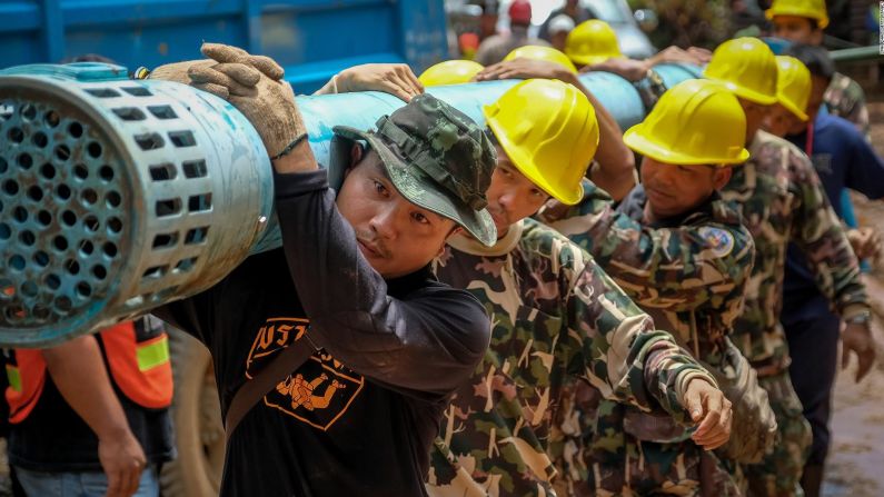 Los trabajadores de rescate llevan equipo de bombeo de agua a la cueva el 1 de julio.