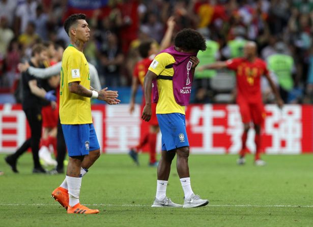 Roberto Firmino y Willian, luego del partido en el que Brasil perdió por 2-1 ate Bélgica. Mientras qe Firmino tiene el rostro adusto, Willian se tapa el rostro.