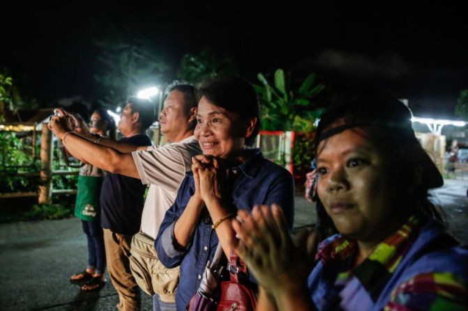 Espectadores vitorean al paso de las ambulancias que trasladaron a los menores rescatados a un hospital en Chiang Rai.