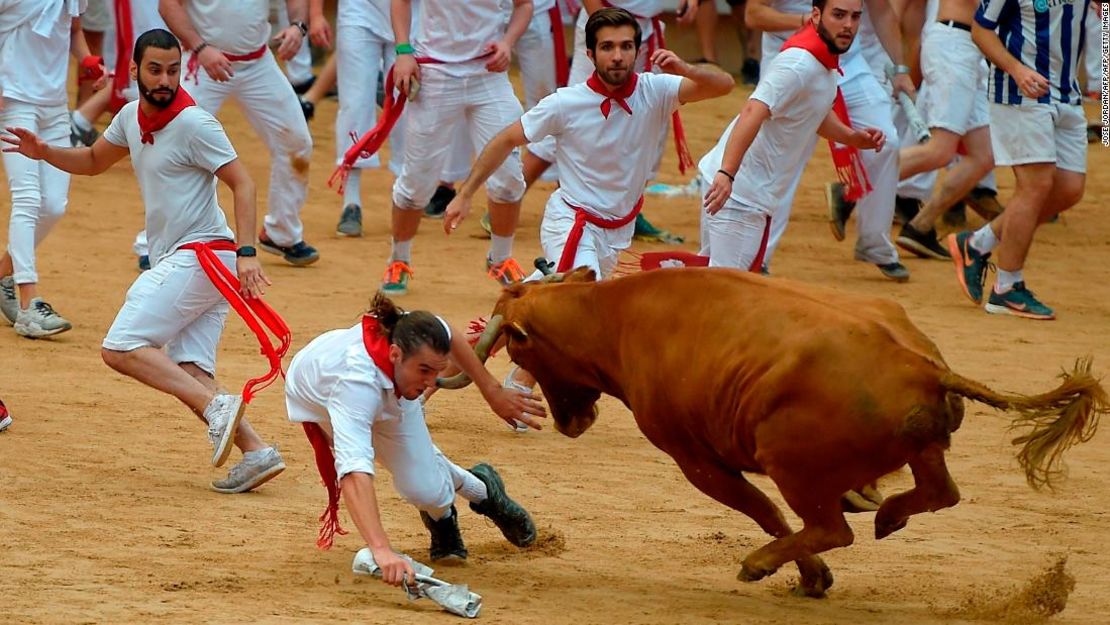 Los aficionados corren delante de los toros con trajes blancos y pañuelos rojos, según marca la tradición.