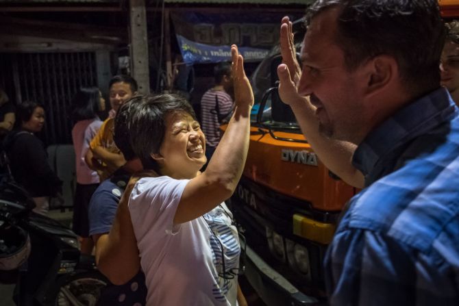 Espectadores en el cruce del hospital Chiangrai Prachanukroh celebran mientras las ambulancias transportaban al último de los niños rescatados el 10 de julio de 2018.