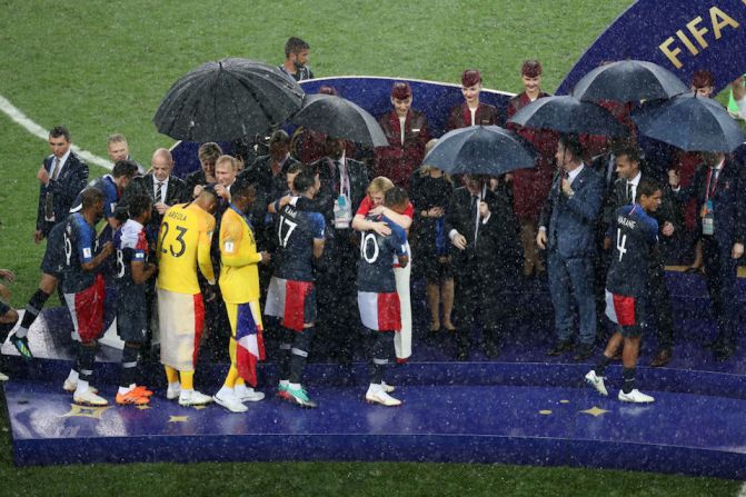 Los jugadores franceses recibieron la copa en una ceremonia bajo un tremendo aguacero, mientras los presidentes de Francia, Croacia y Rusia se cubrían con varios paraguas.