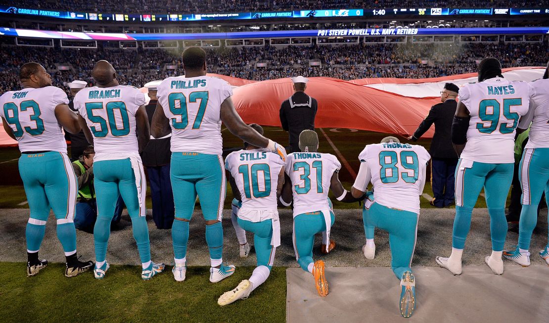 Jugadores de los Miami Dolphins se arrodillan durante el himno nacional en un partido en noviembre de 2017.