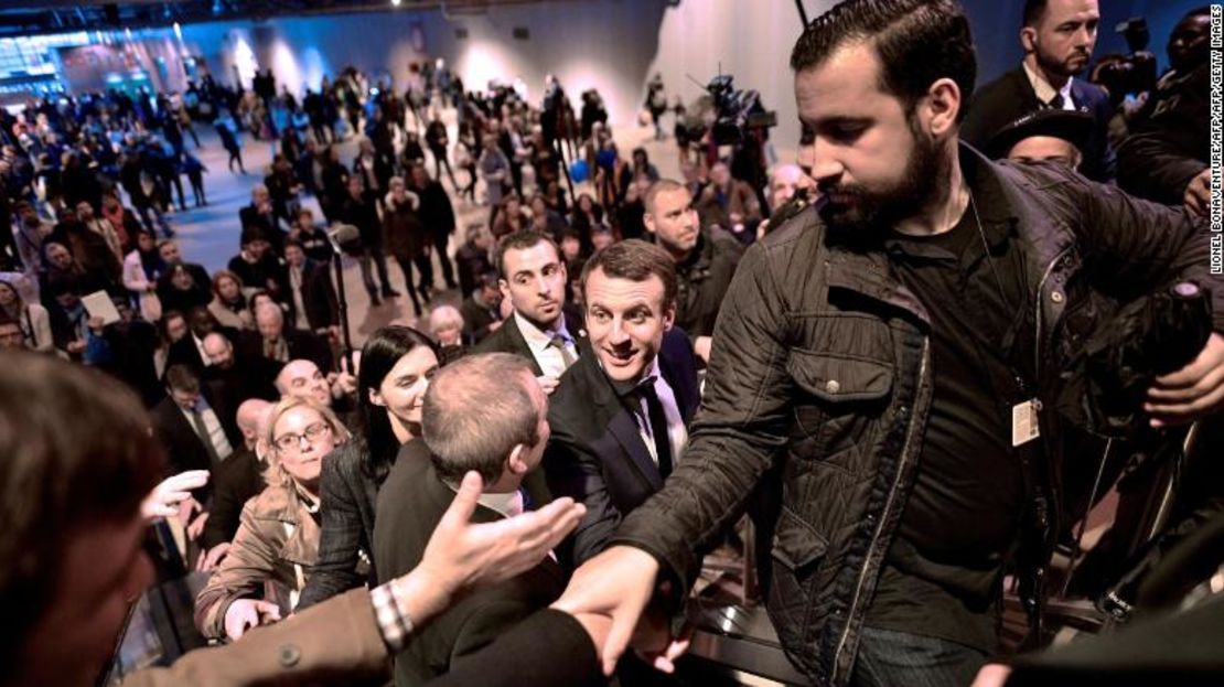 Emmanuel Macron, al centro, saluda a la multitud durante una visita a la feria internacional de agricultura de París en marzo de 2017, mientras su jefe de seguridad Alexandre Benalla, a la derecha, despeja el camino.