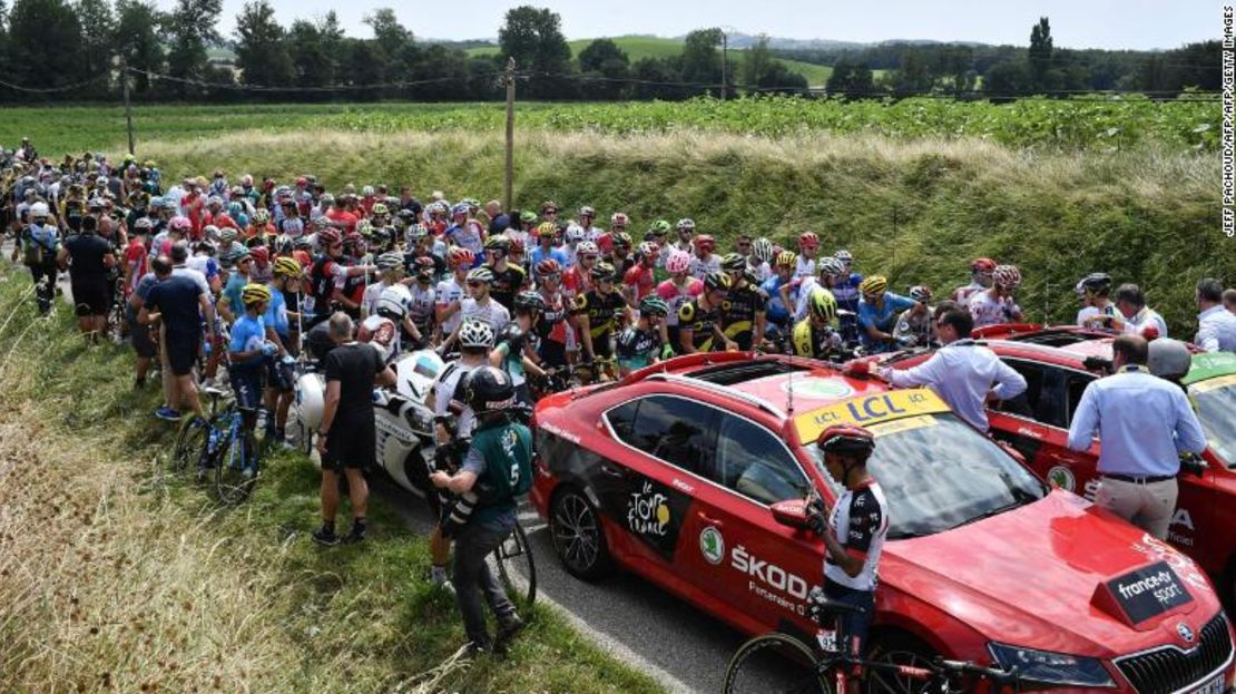 El grupo de ciclistas espera a que la etapa del Tour de Francia se reanude.