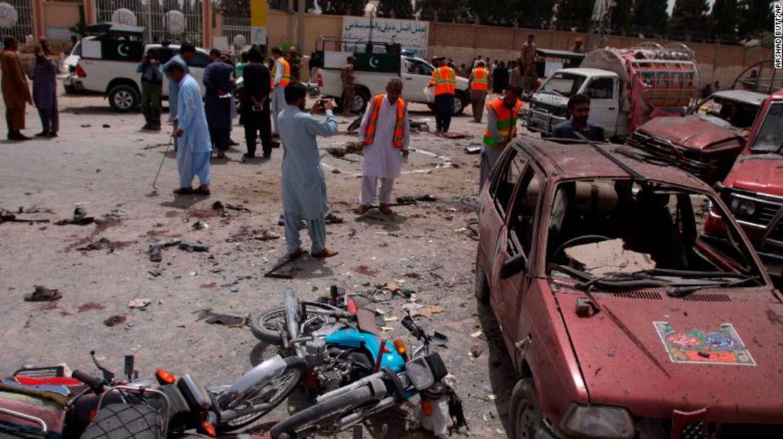 Voluntarios y agentes de seguridad paquistaníes visitan el sitio de la bomba en Quetta.