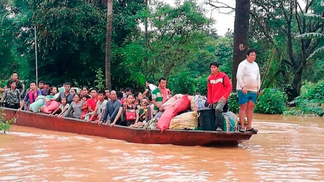 En esta foto, un bote lleno de personas es evacuado en medio de las inundaciones provocadas por la represa.