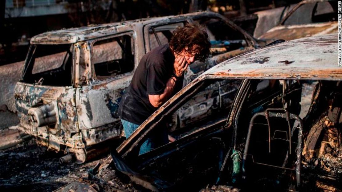 Una mujer busca a su perro después del incendio en Mati, cerca de la capital griega, Atenas.