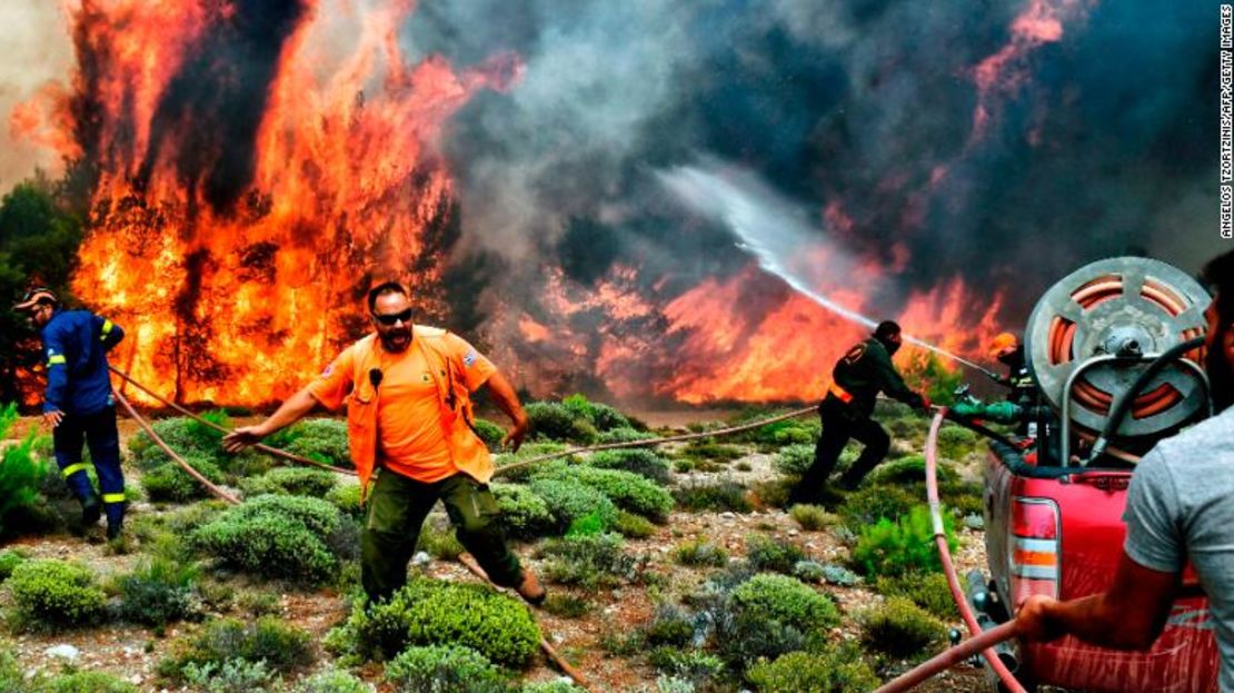 Bomberos y voluntarios trabajan para extinguir las llamas de un incendio el 24 de julio.