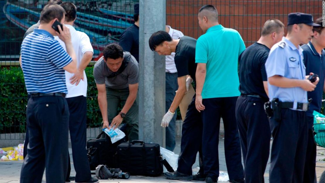 Agentes de seguridad inspeccionan el área tras una explosión cerca de la embajada de Estados Unidos en Beijing, China.