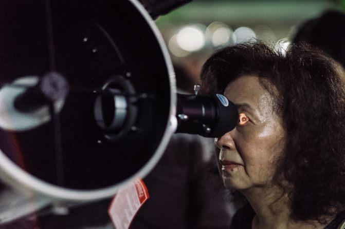 Una mujer utiliza los telescopios para observar el eclipse lunar cerca del salón conmemorativo nacional del Dr. Sun Yat-sen, Taipei, Taiwán.