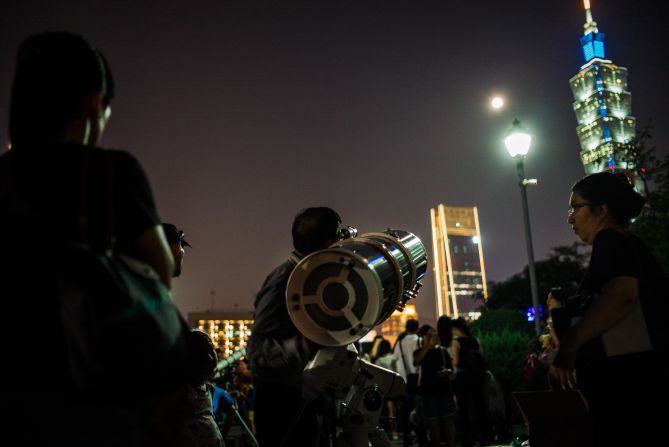 El eclipse lunar también llevó a que varias personas salieran a las calles de Taipei, en Taiwán. En la imagen, algunos ubican sus telescopios para apreciar mejor el fenómeno.