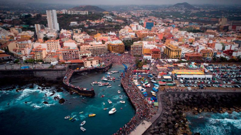 Puerto de la Cruz, Tenerife, España. Esta imagen muestra el festival de la Virgen del Carmen que honra a la patrona de los pescadores en la isla española de Tenerife. Los locales llevan una estatua de la Virgen del Carmen a bordo de un barco adornado y navegan a lo largo de la costa.