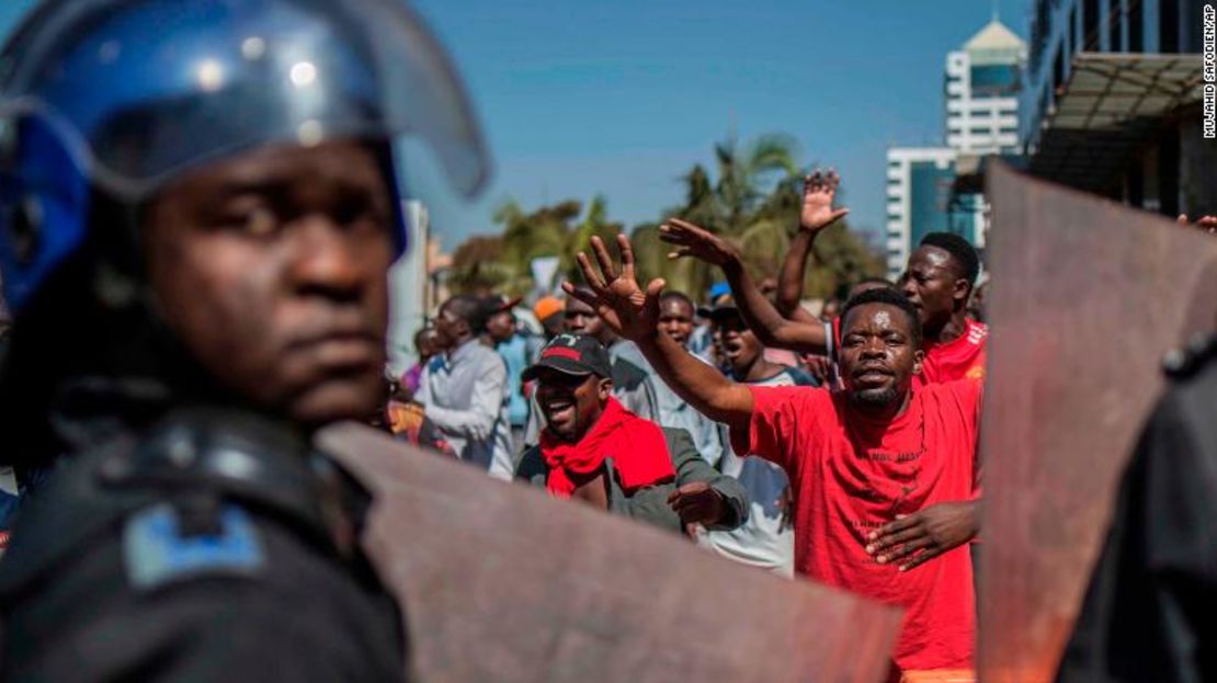 La policía patrulla fuera de las oficinas de la Comisión Electoral de Zimbabwe mientras los partidarios de la oposición se reúnen en Harare.