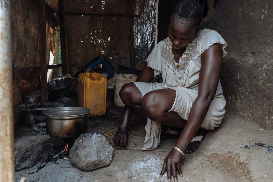 Angeline, una mujer de Sudán del Sur, fotografiada haciendo un fuego en su cocina.