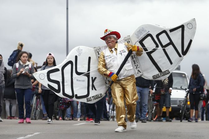 Uno de los manifestantes en Bogotá carga unas alas con el mensaje "Soy paz" mientras participa en las protestas que se realizaron el día de la posesión del nuevo presidente de Colombia, Iván Duque.