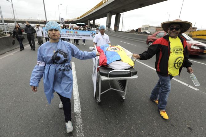 Manifestantes arrastran una camilla que representa el asesinato de los líderes sociales en Colombia, durante las protestas que se realizaron contra el presidente Iván Duque el día de su posesión.