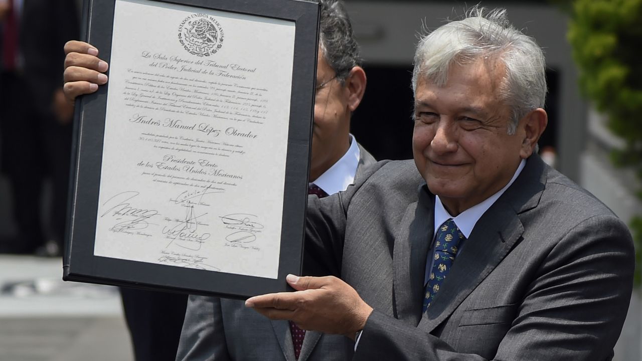 Mexican President-elect Andres Manuel Lopez Obrador shows a document after he was officially endorsed by the Federal Electoral Tribunal as the elected president in Mexico City on August 8, 2018. (Photo by ALFREDO ESTRELLA / AFP)