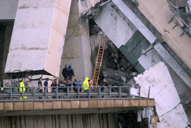 Rescatistas avanzan entre una enorme porción del puente colapsado.