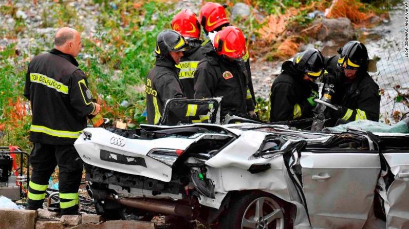 Rescatistas trabajan para sacar de este auto a una persona herida.