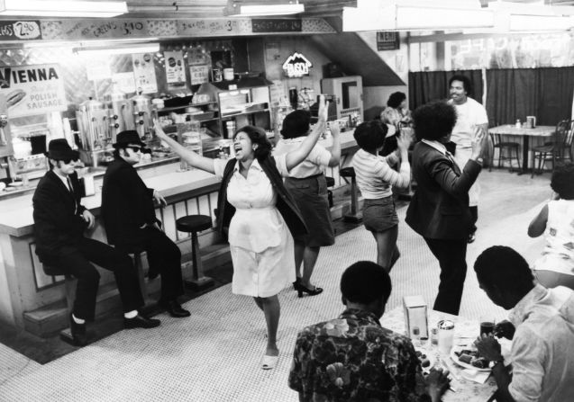 Dan Aykroyd (a la extrema derecha), John Belushi (segundo a la izquierda), Aretha Franklin (al centro), y Matt “Guitar” Murphy (atrás a la derecha) en escena durante la película de 1980 “The Blues Brothers”.