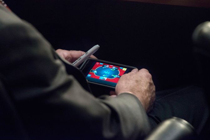 McCain juega al póquer en su iPhone durante una audiencia del comité del Senado en septiembre de 2013.