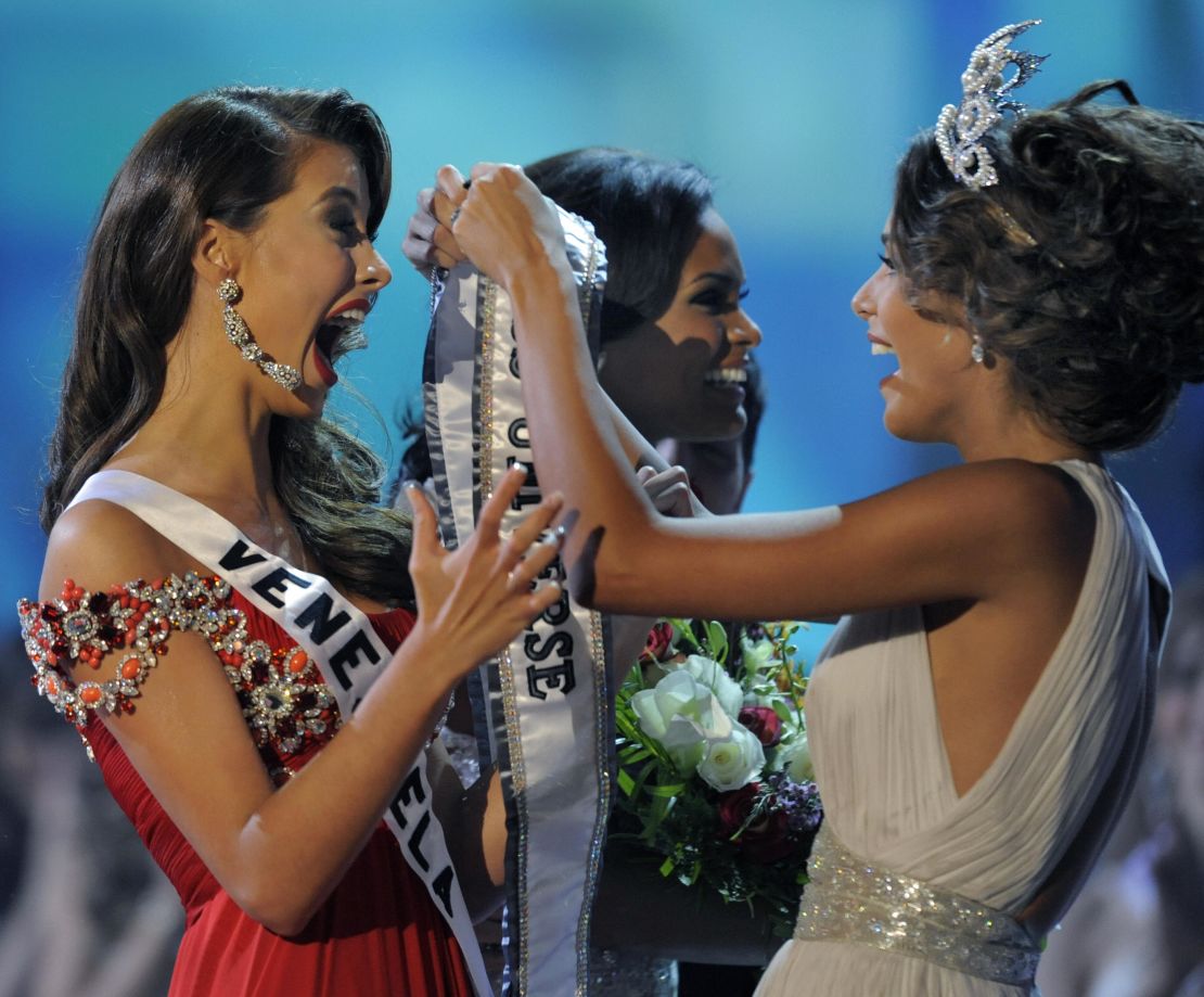 Momento en el que Dayana Mendoza corona y entrega la banda de Miss Universo a su compatriota venezolana, Stefanía Fernández.