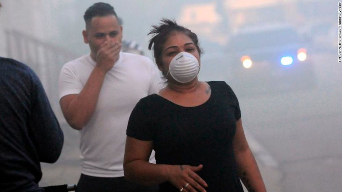 Los residentes se cubren la boca para protegerse del humo mientras evacuaban el jueves en Lawrence, Massachusetts.