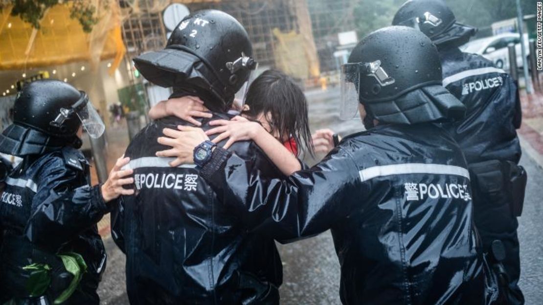 Policías sacan a una niña de una escuela que colapsó en Hong Kong el domingo.