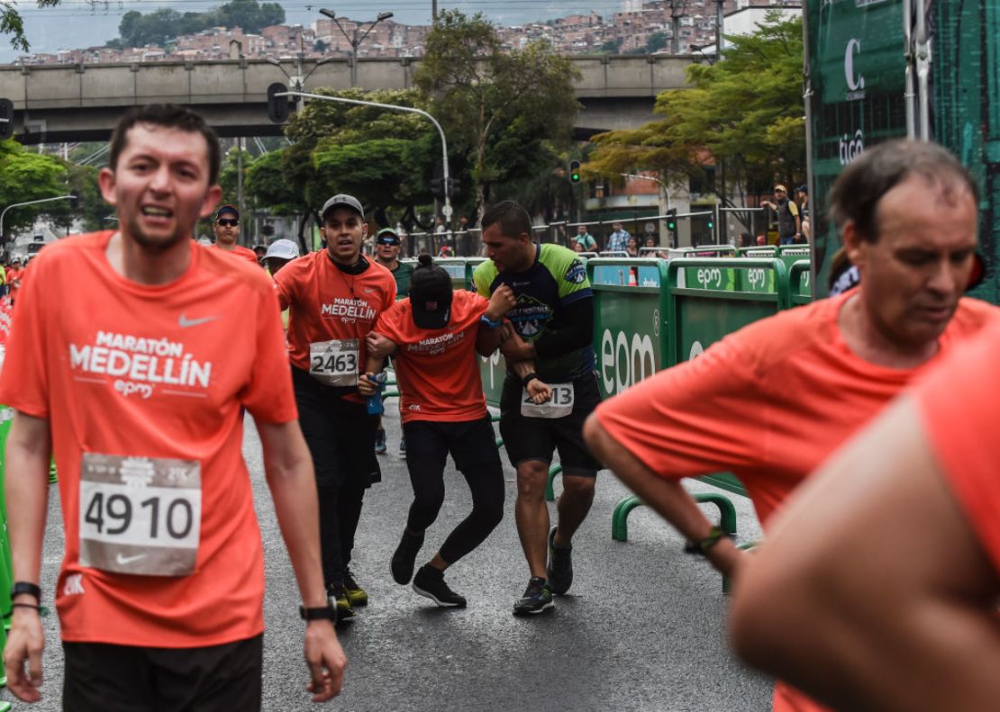El corredor Juan Camilo Arboleda Alzate es atendido por personal de primeros auxilios tras cruzar la meta de la Media Maratón de Medellín.