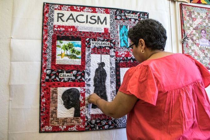 Sylvia Hernández retoca una de sus obras que habla sobre racismo y violencia.
