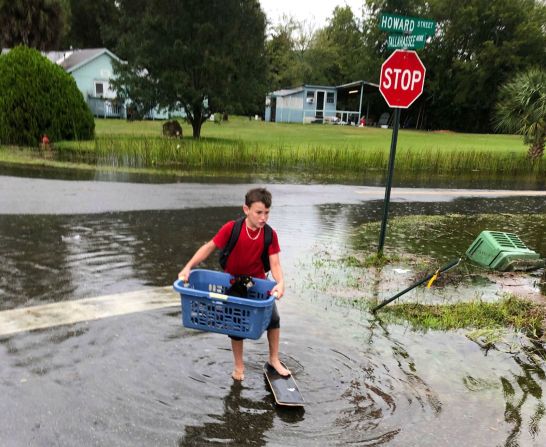 Jayden Morgan, de 11 años, evacua su casa mientras el agua comienza a subir en su vecindario, en St. Marks.