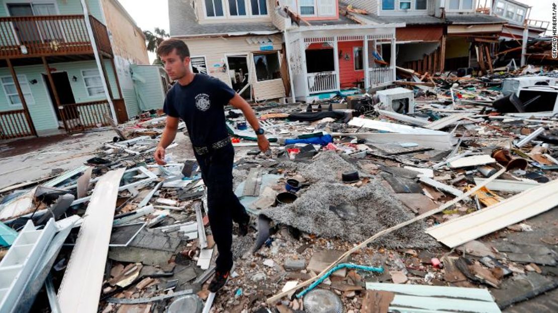 Un bombero busca puerta por puerta después del huracán Michael en Mexico Beach.