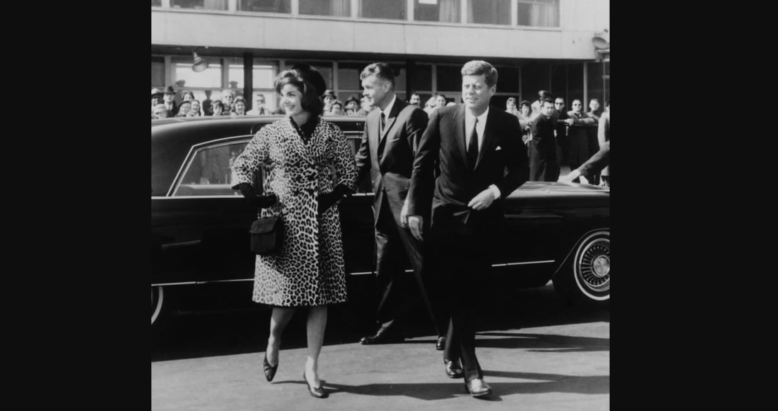 Escoltada por el presidente Kennedy, Jacqueline Kennedy sale para un viaje a India y Pakistán con un abrigo de piel de leopardo de Oleg Cassini, en 1962.