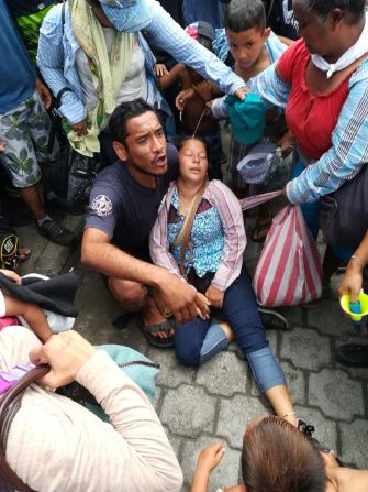 Una mujer yace desmayada en el piso del paso fronterizo, mientras miles de personas buscan cruzar de Guatemala hasta México el 19 de octubre de 2018.