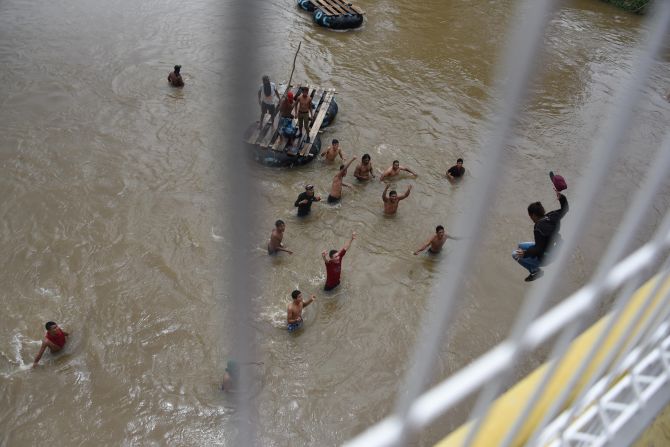 Los migrantes en el puente fronterizo de Tecún Umán han saltado al río Suchiate en medio del bloqueo de las autoridades mexicanas y el calor.