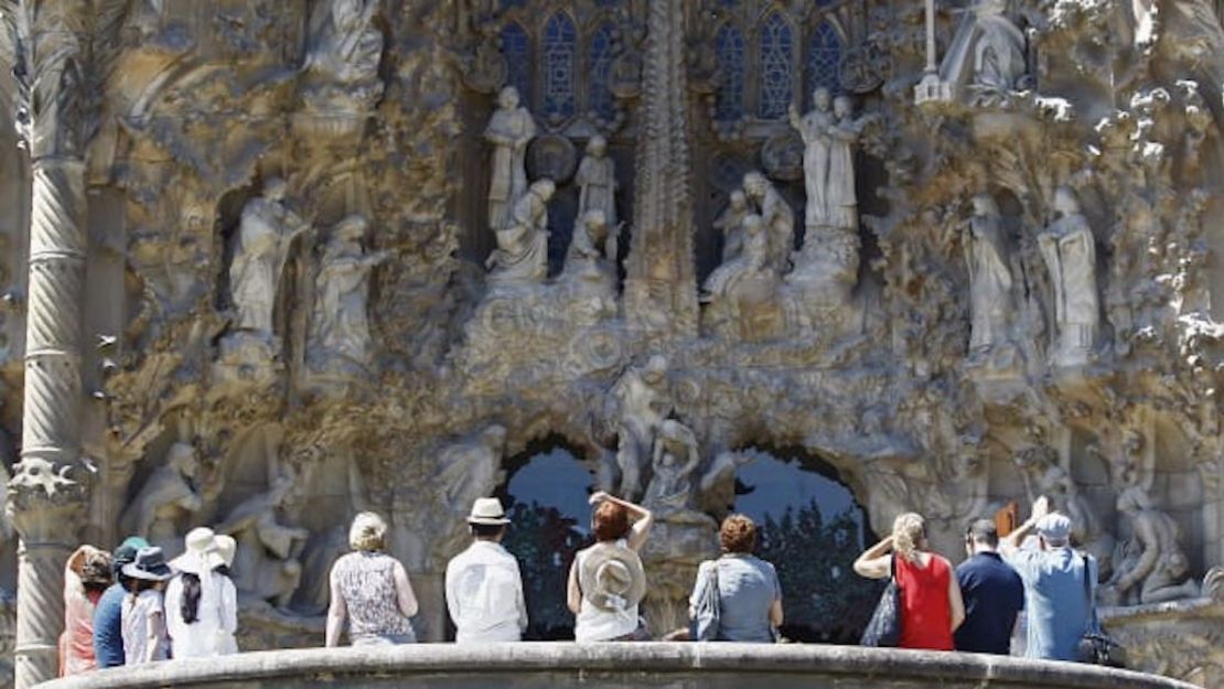 Turistas admiran el diseño intrincado del exterior de la Sagrada Familia.