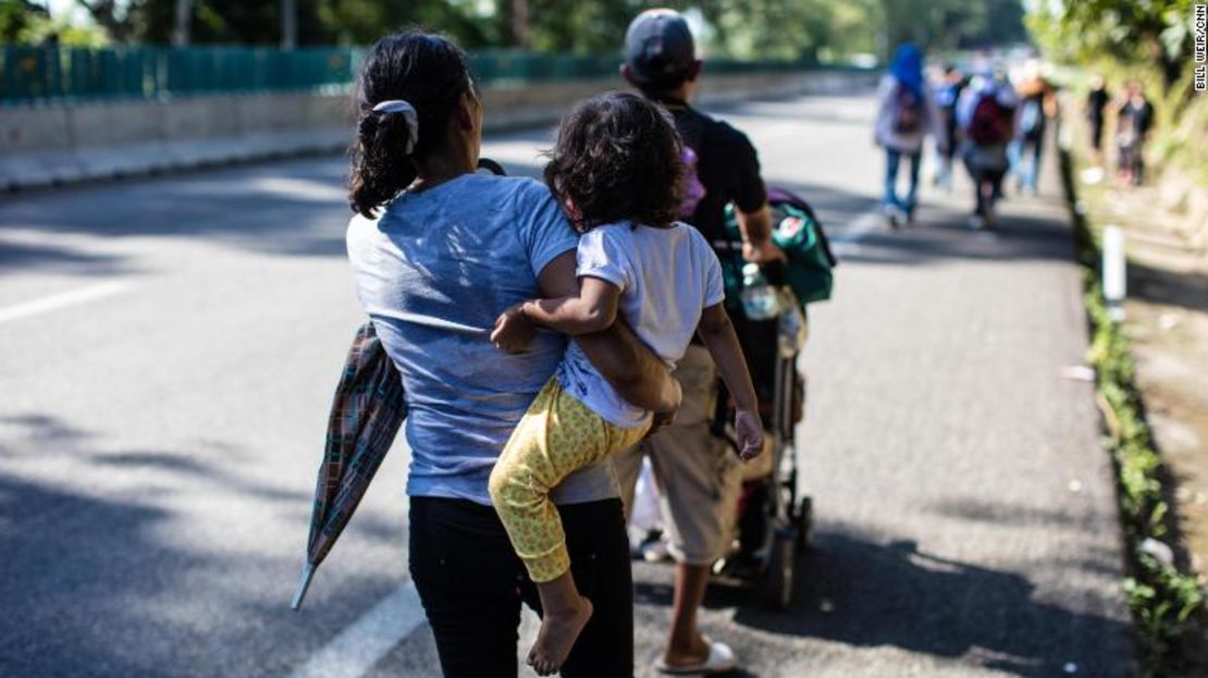 Una migrante alza a un niño mientras la caravana camina hacia el norte desde Tapachula.