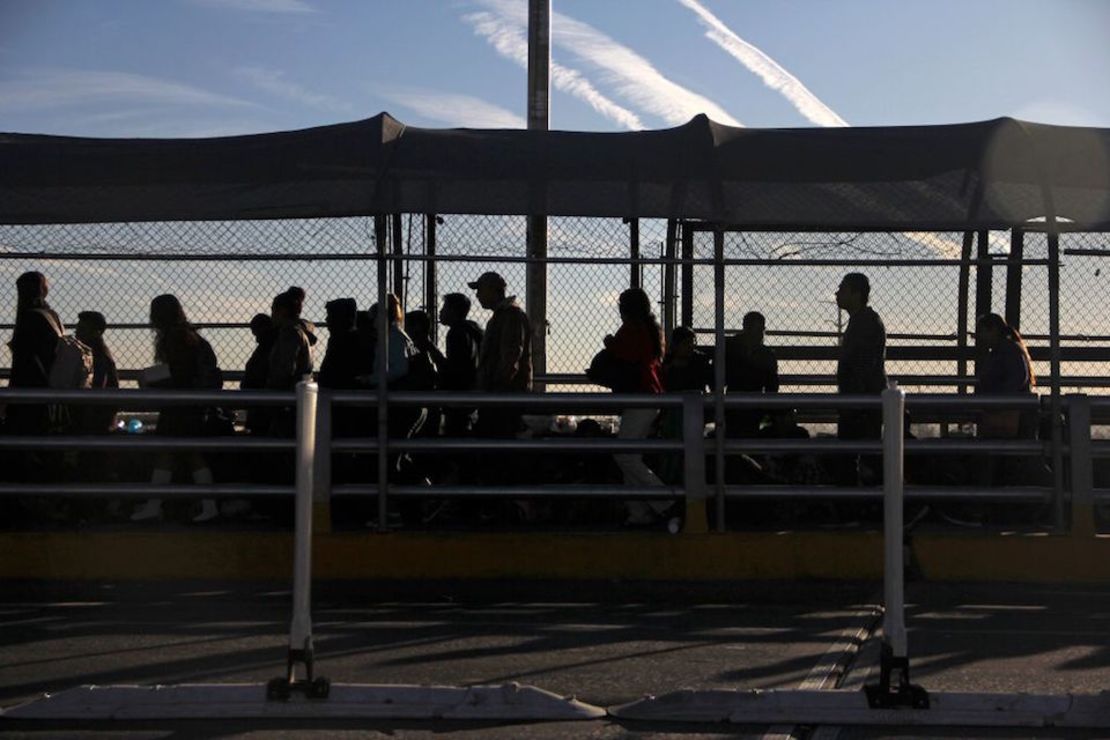 Inmigrantes esperan en el puente internacional del Paso del Norte, en Ciudad Juárez, México, en la frontera con Estados Unidos.